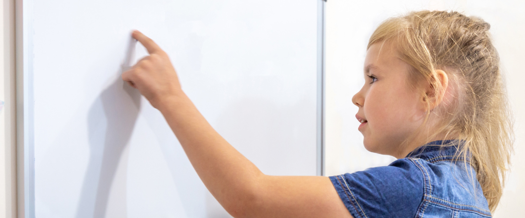 Young female student pointing at a whiteboard.