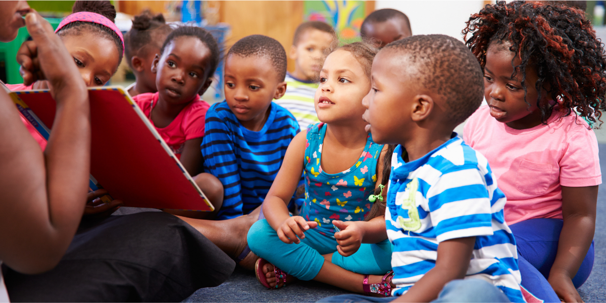 Teacher showing a book to children