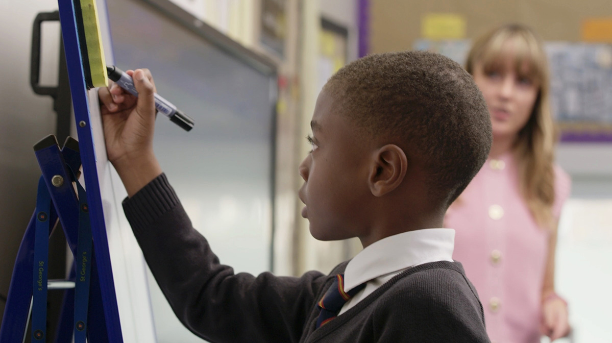 Boy writing on whiteboard